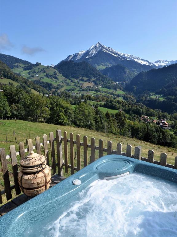 a hot tub with a view of a mountain at Les chambres et Roulottes des Noisetiers in Leysin