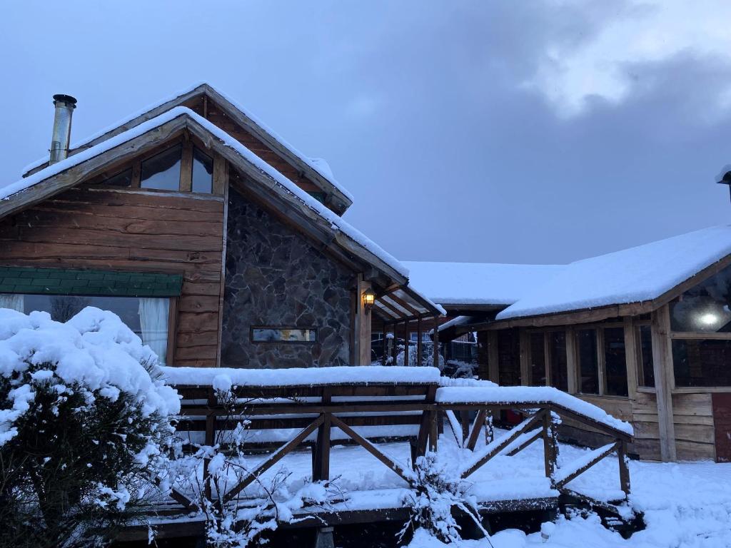 a log cabin with snow on the roof at Cabañas en Malalcahuello con agradable Barbacoa y 2 Estacionamientos Techados in Malalcahuello