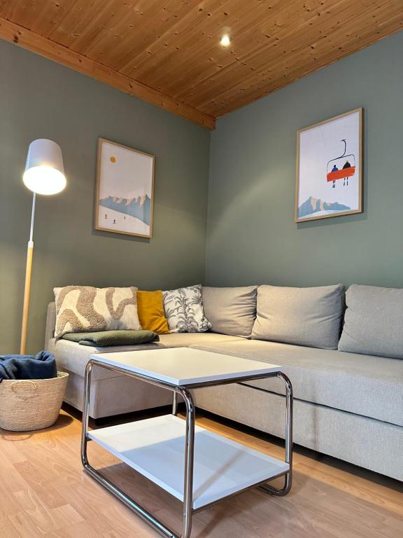 a living room with a couch and a table at Apartment Auszeit im Ski- und Wandergebiet Spitzingsee - neu renoviert in Schliersee
