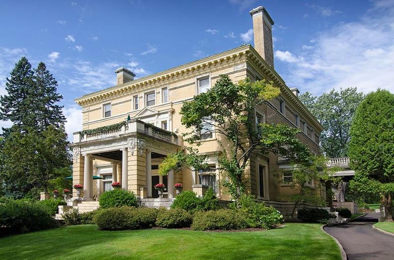 a large yellow house with a lawn in front of it at Historic Cotton Mansion by Heirloom Boutique Collection in Duluth