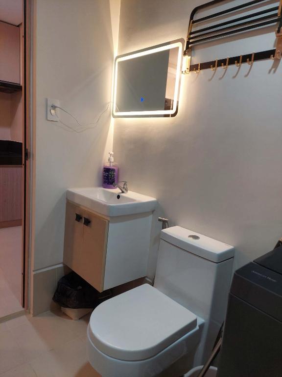 ein Badezimmer mit Toilette, Waschbecken und Spiegel in der Unterkunft SM Style in Iloilo City