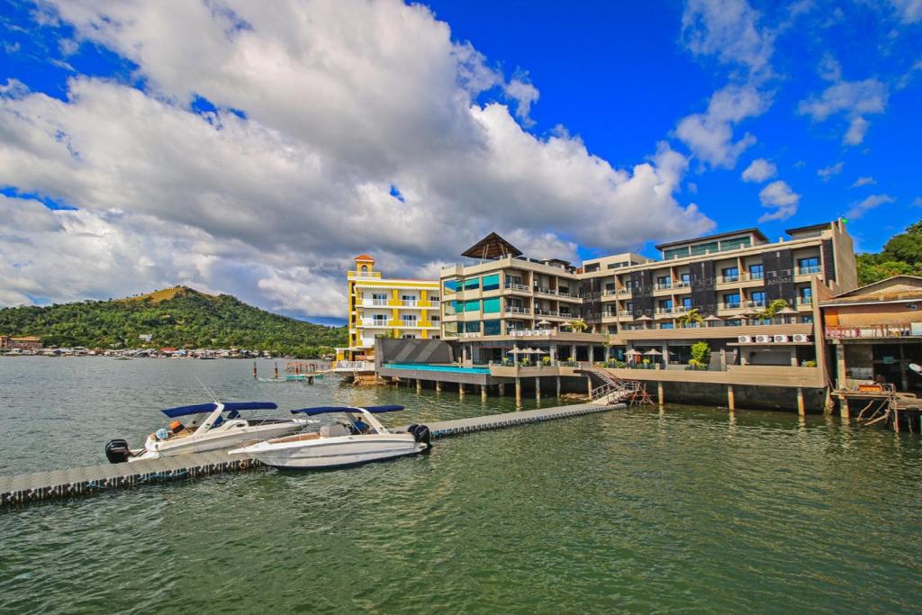 a boat is docked at a dock in front of a hotel at Two Seasons Coron Bayside Hotel in Coron
