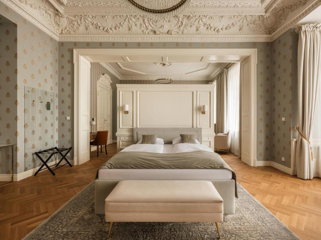 a bedroom with a bed and a wall with wallpaper at Hotel Traugutta 12 in Łódź