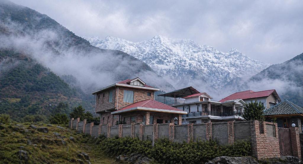 a group of houses on a hill with mountains in the background at Casa Ramona Luxury Villa With Hot Tub Near Dharamshala Palampur in Pathyar