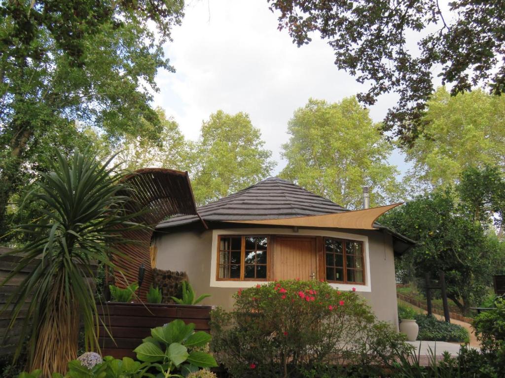 a small house in the middle of a garden at Pumula Luxury Camps in Lions River