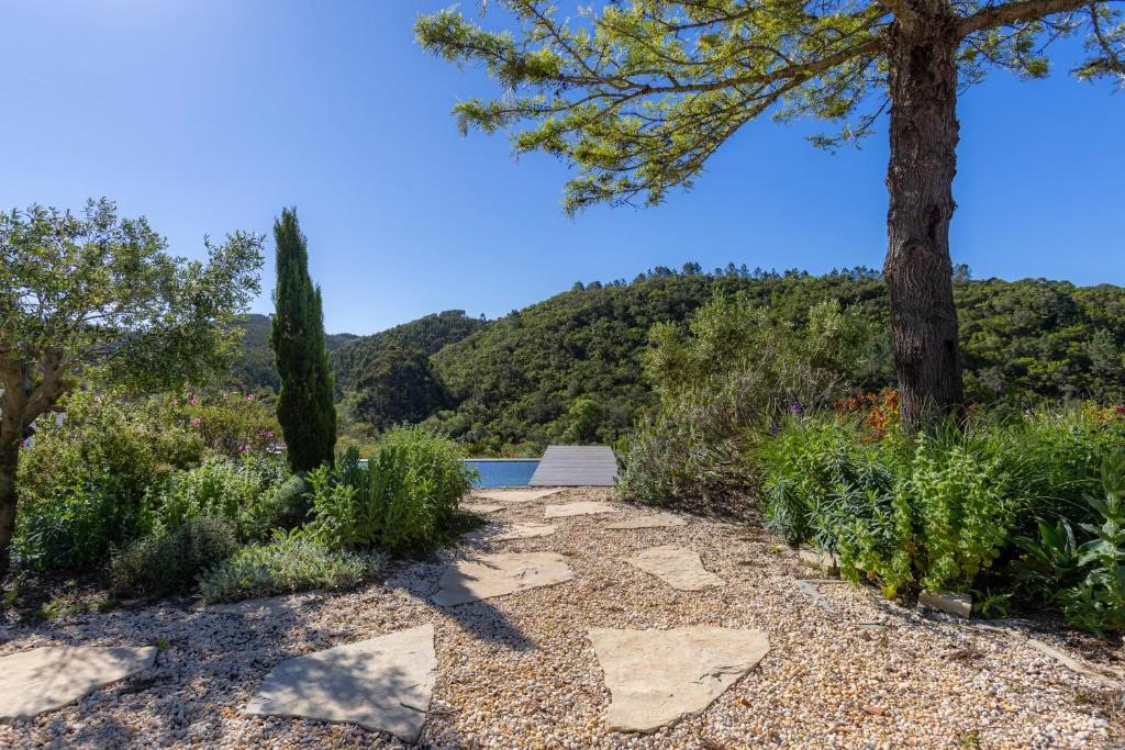 a walkway with trees and a view of a mountain at Quinta Javali in Aljezur