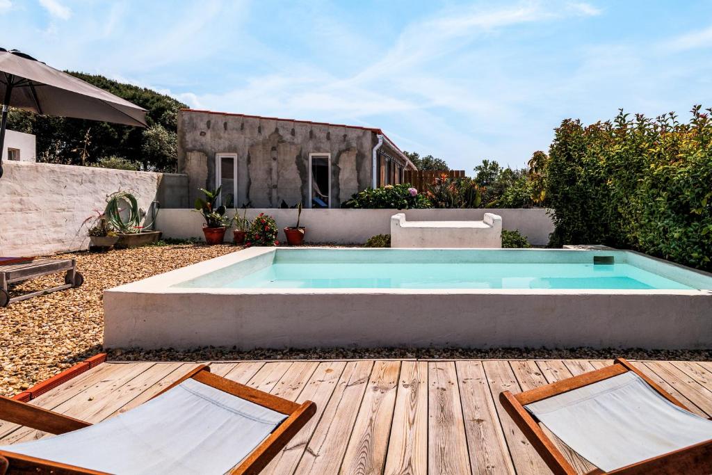 a swimming pool in a yard with a wooden deck at Cozy Suite À Da Marina in Quinta do Poço