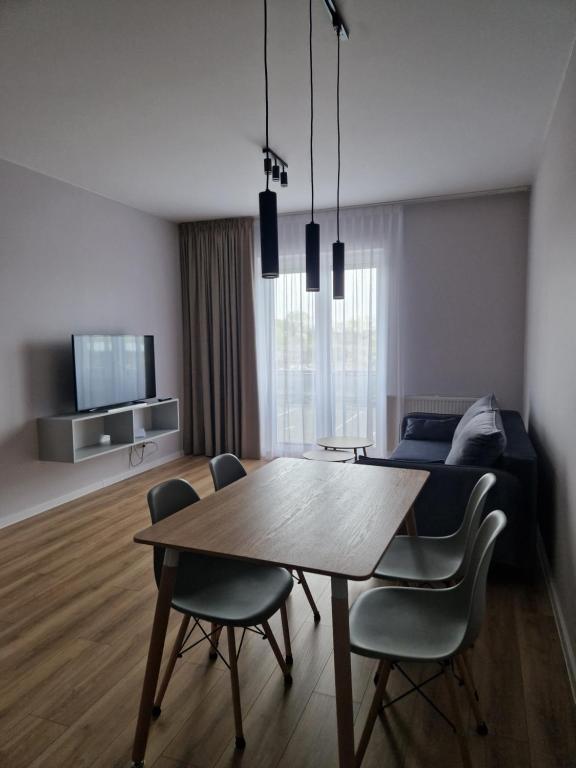 a living room with a table and chairs and a bed at Apartament Marzeń 13 in Kostrzyn nad Odrą