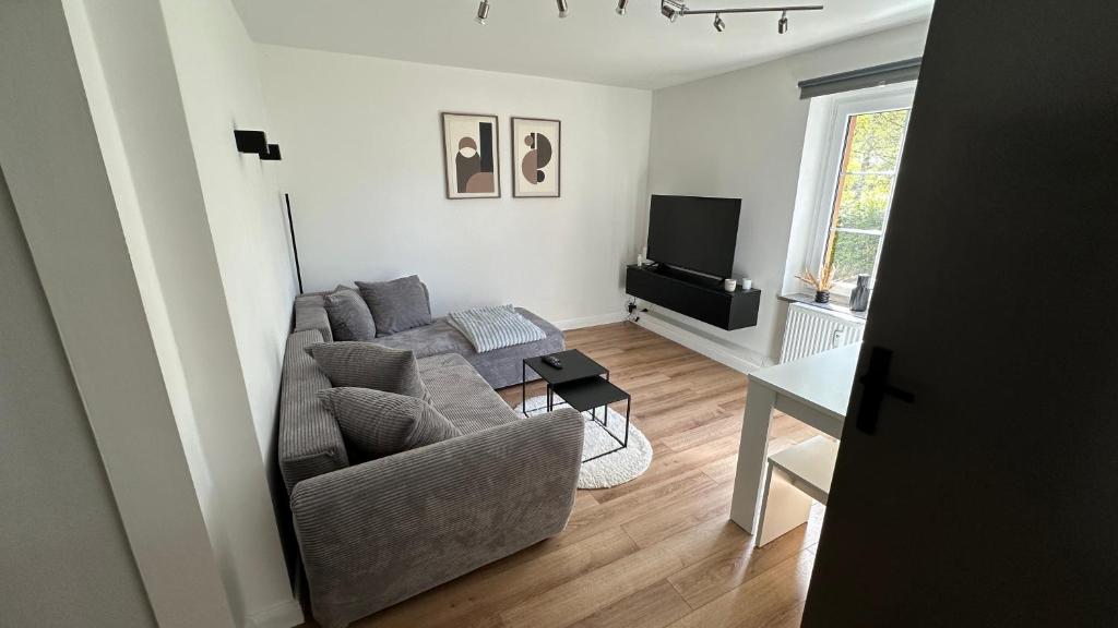 a living room with a couch and a television at Am Gebirgsbad in Kurort Jonsdorf