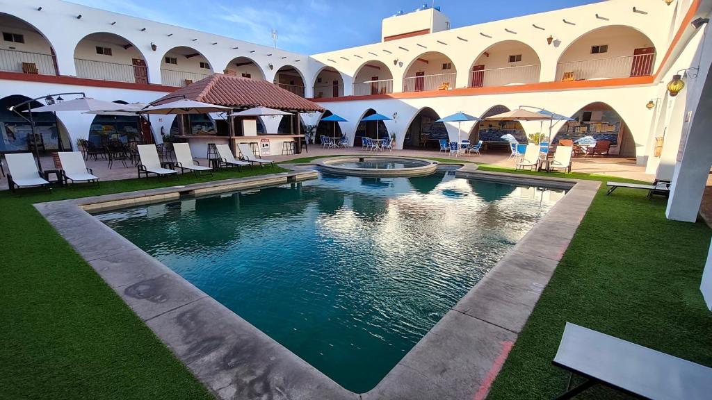 an outdoor swimming pool in a courtyard of a building at Hotel Hacienda Bugambilias La Paz in La Paz