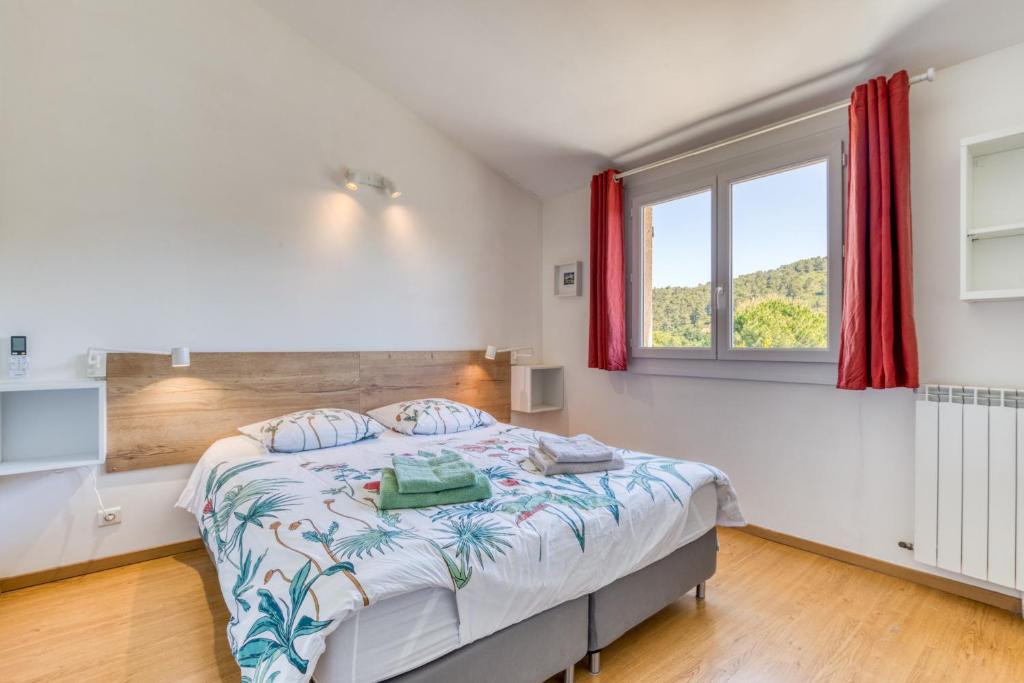 a bedroom with a bed and a window at Les Pénates De Mélilotte in Clermont-lʼHérault