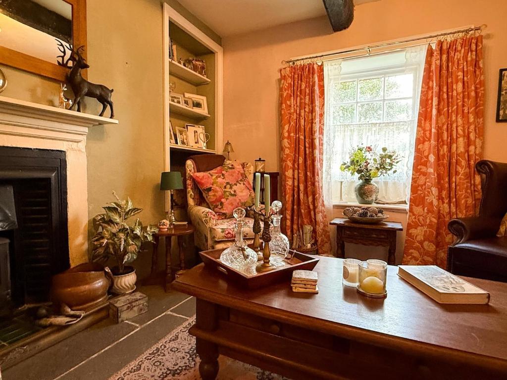a living room with a coffee table and a fireplace at Wingrove Cottage - Sleeps 8 in Morland