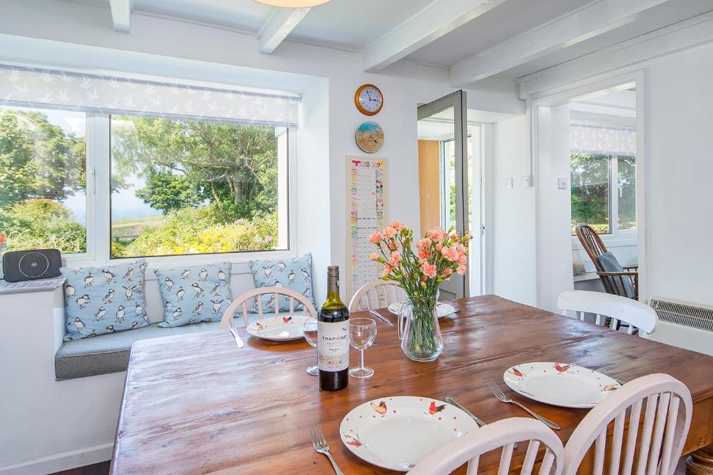 a dining room with a table with a bottle of wine at 2 Caerau Isaf in Haverfordwest