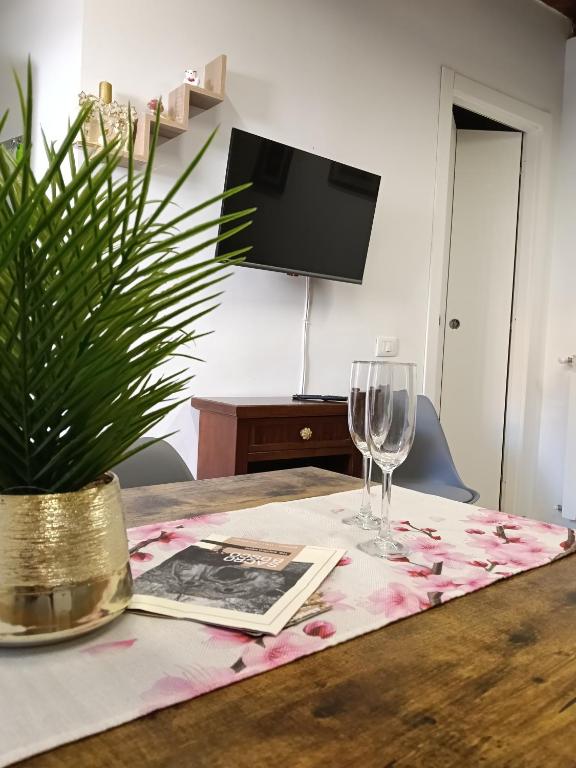 a table with a glass of wine and a plant at La casetta di nonna Sesa in Viterbo