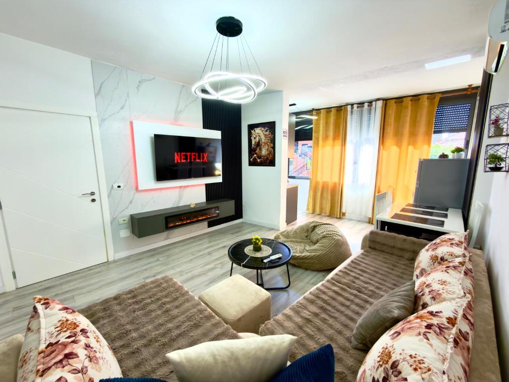 a living room with a couch and a tv at Boku Apartments Pazari i Ri 2 in Tirana