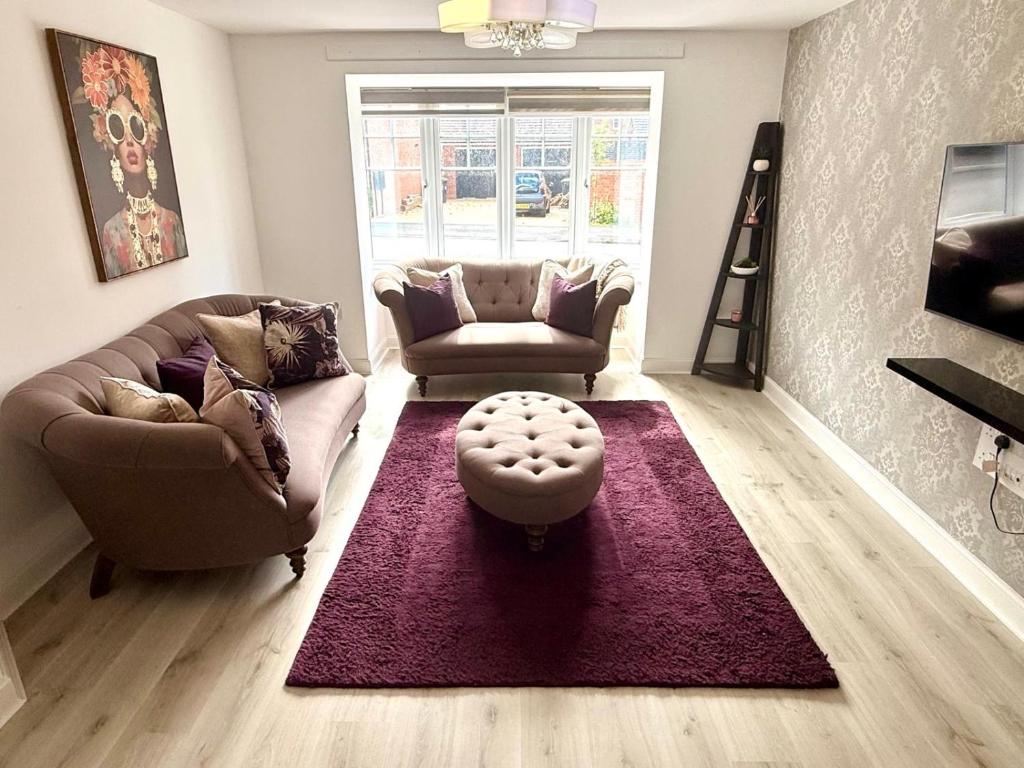 a living room with two couches and a purple rug at Chislehurst House in Bedford