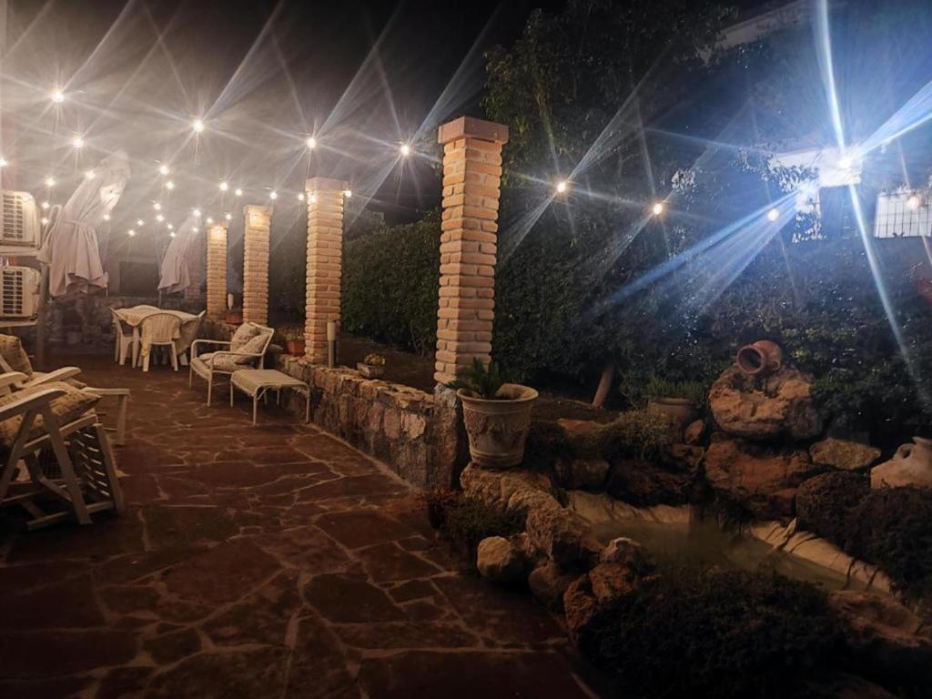 a patio with tables and chairs at night with lights at Casa Scopelliti Calasetta in Calasetta