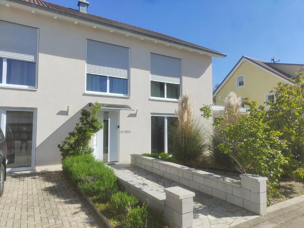 a white house with windows and a driveway at Loft apartment für bis zu 4 Personen in Malterdingen