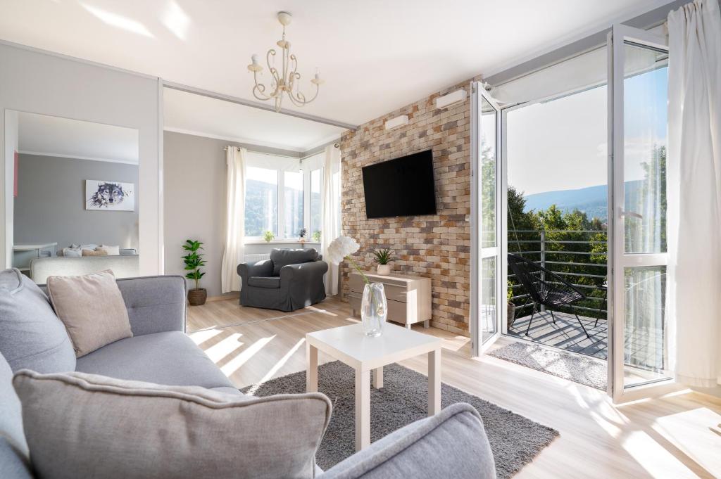 a living room with a couch and a tv at Apartamenty Izerskie - ul. Cicha 13D-E in Świeradów-Zdrój
