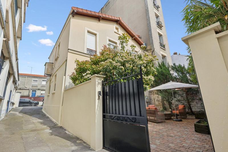 a white house with a black gate and an umbrella at Loft Fraternité in Bagnolet