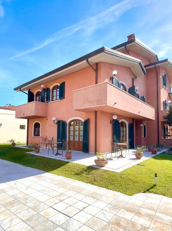 a large pink house with a balcony at Villa Silvana in Querceta