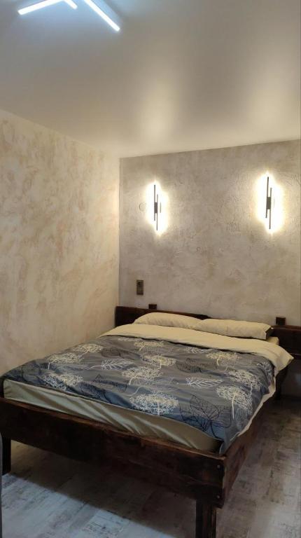 a bedroom with a bed with two lights on the wall at Подобово Центр in Konotop