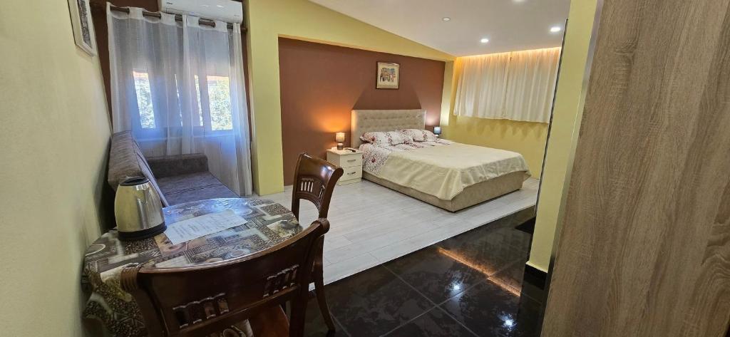 a bedroom with a bed and a glass table at CityCenterHotel Shkoder in Shkodër