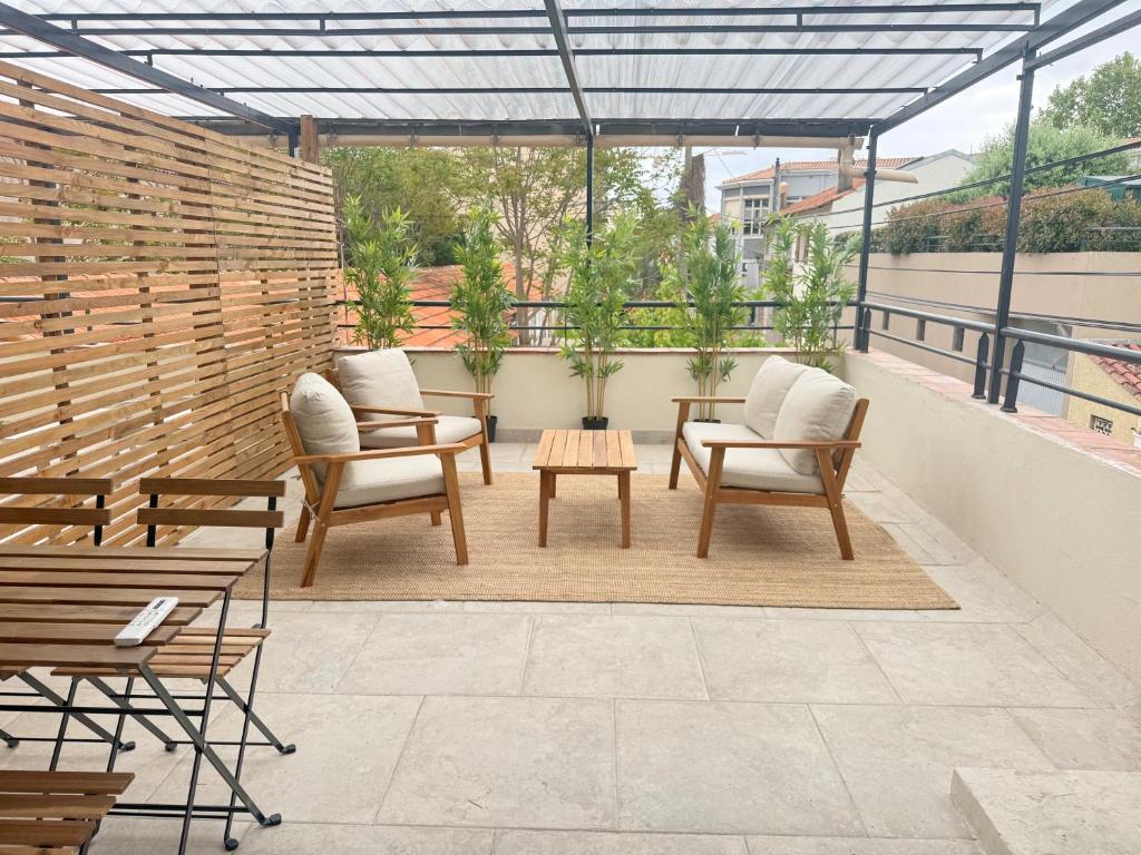 a patio with chairs and tables on a roof at L'Esterel Appartements Plage 450m & Gare Saint-Raphael 950m in Fréjus