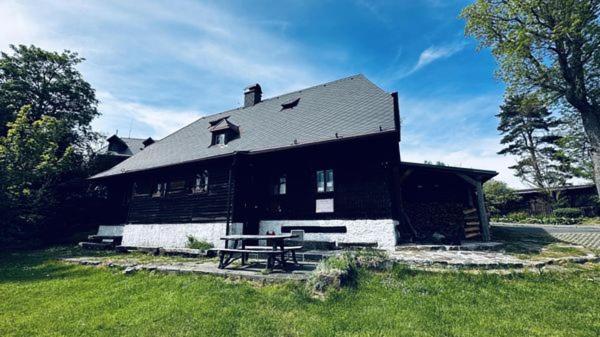a black house with a picnic table in front of it at U Jakuba - Boba in Prášily