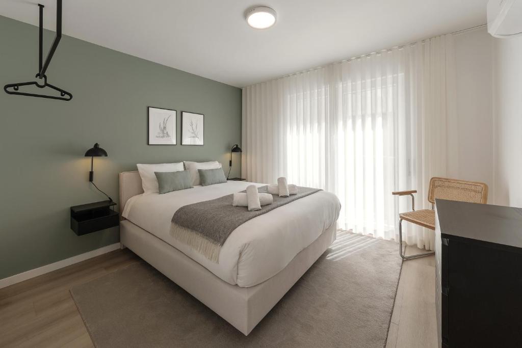 a bedroom with a large bed with two candles on it at Casa Jacinto 9 in Caldas da Rainha
