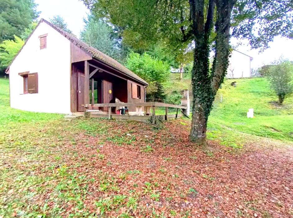 a small house in a field with a tree at Le break vert in Lacapelle-Viescamp