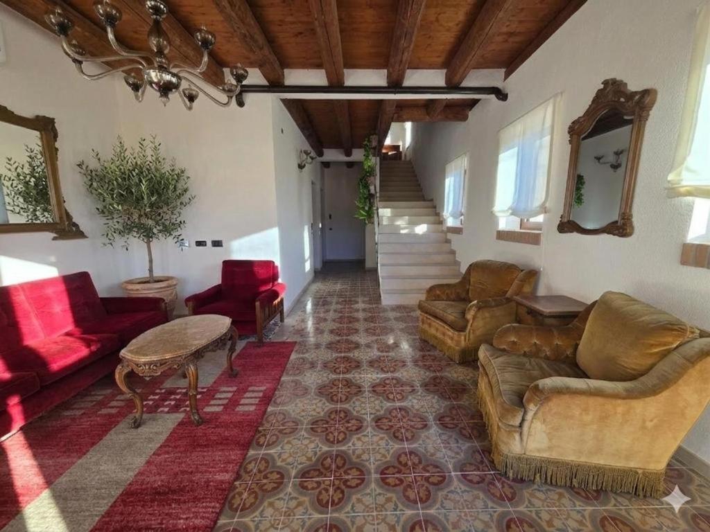 a living room with a couch and a table and chairs at Agriturismo Maison Oro Verde in Verona