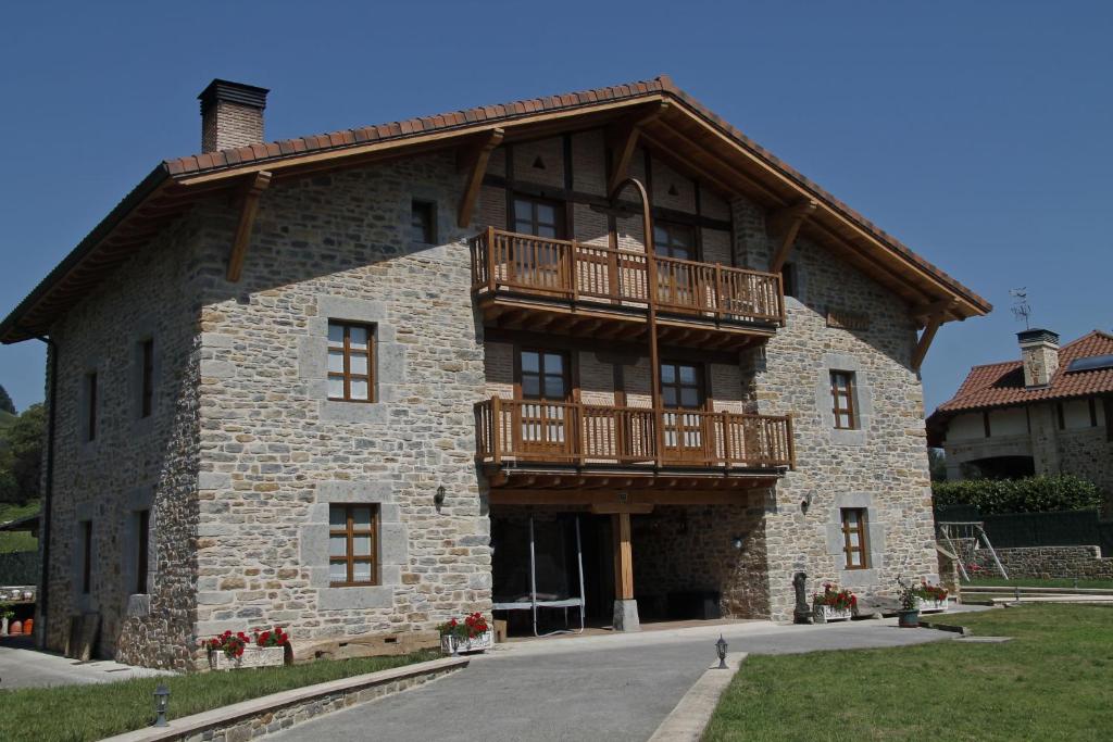a large stone building with a balcony on it at Mendiko Baserria in Amurrio