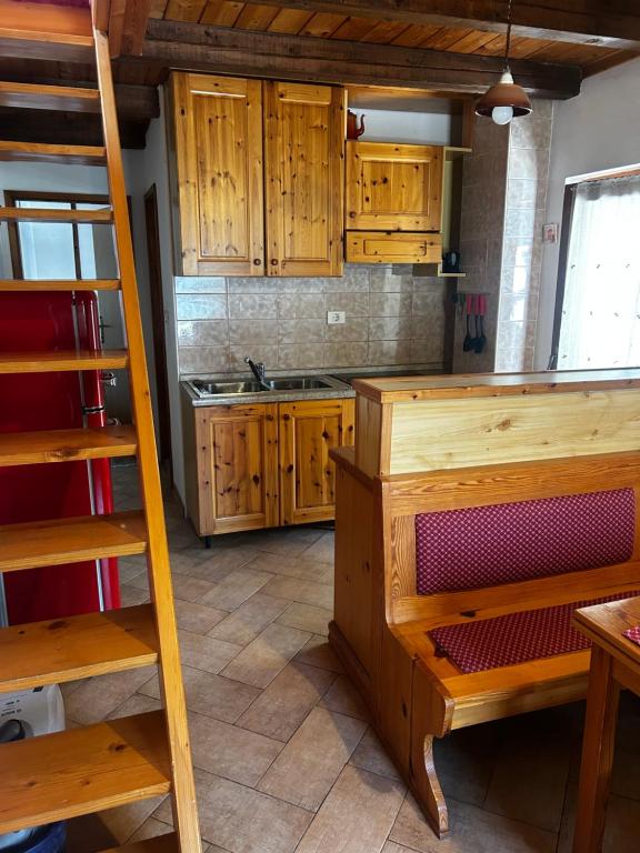 a kitchen with wooden cabinets and a ladder at Bovec Center Stay in Bovec