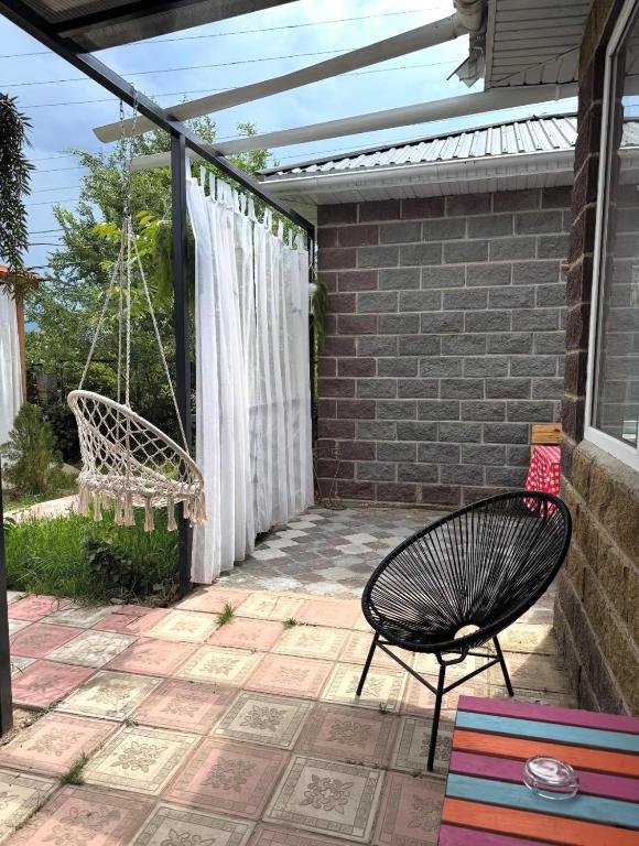 a patio with a chair and a swing at The Bay Area in Cholpon-Ata