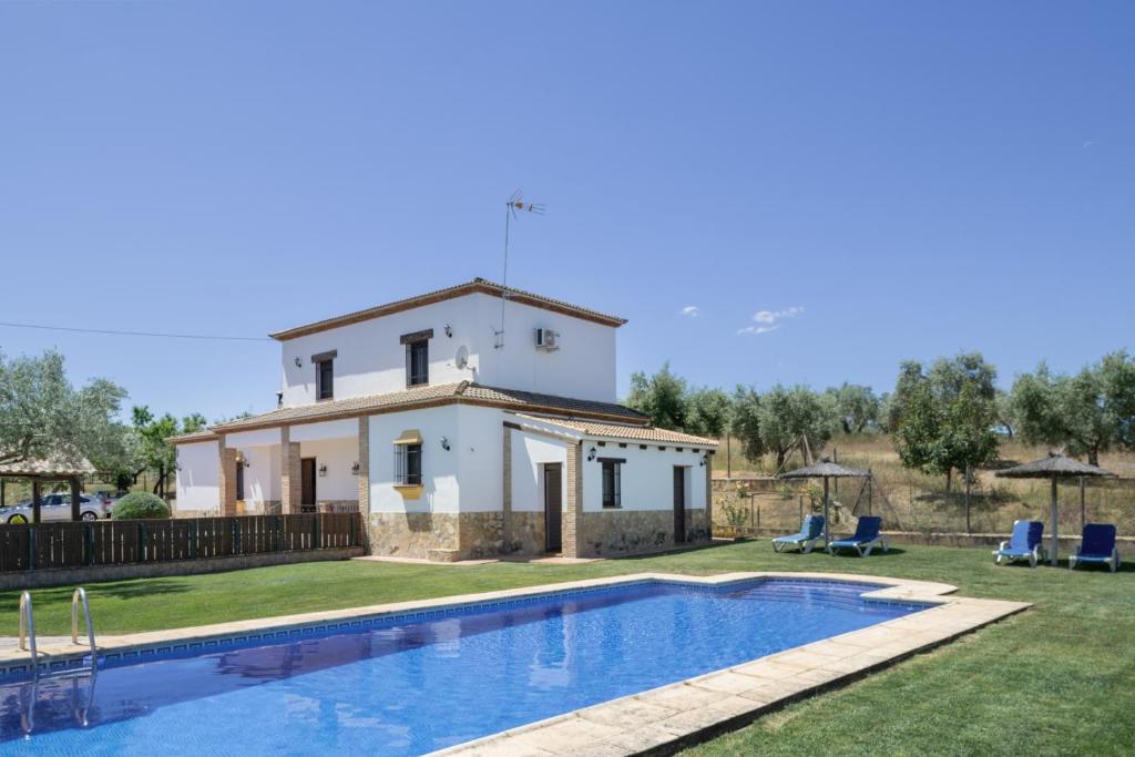 a villa with a swimming pool in front of a house at La Pedrosa in La Cimada