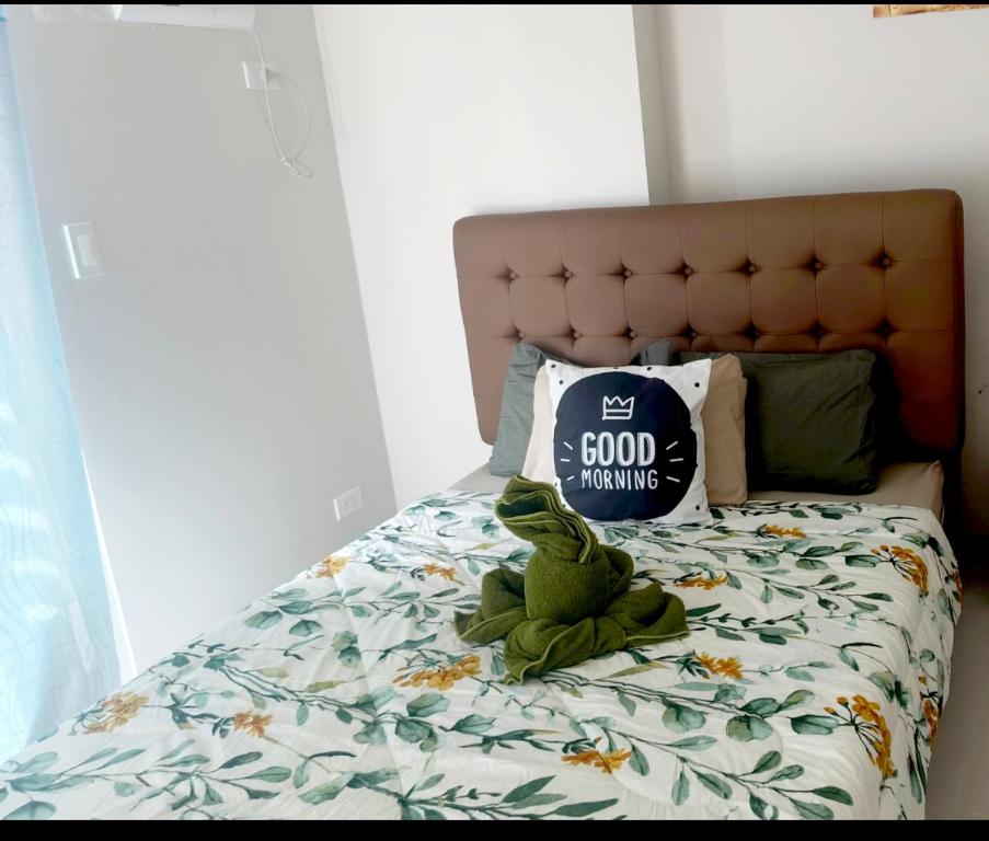 a stuffed frog sitting on top of a bed at Onelakeshore back smx lanang in Davao City