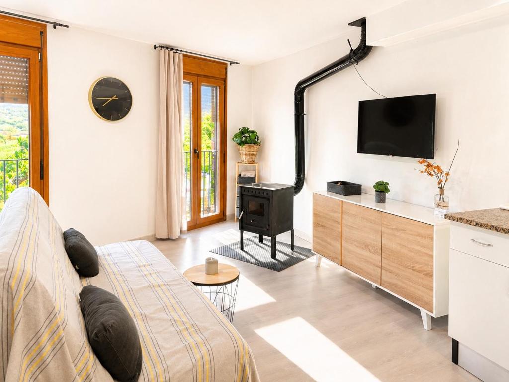 a living room with a couch and a flat screen tv at Apartament Gritella ( Cim Apartaments ) in Cornudella