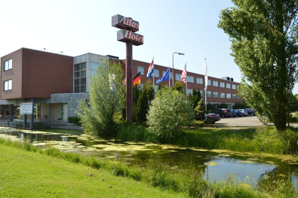a sign in front of a building with flags at Atlas Hotel Holiday in Spijkenisse
