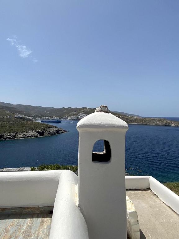 a white building with a window in front of the water at Sto Faro - Blue in Kithnos