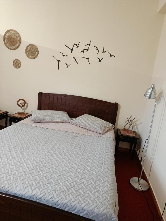 a bedroom with a bed with birds on the wall at ΔΙΑΜΕΡΙΣΜΑ ΣΤΟ ΚΕΝΤΡΟ in Tripoli