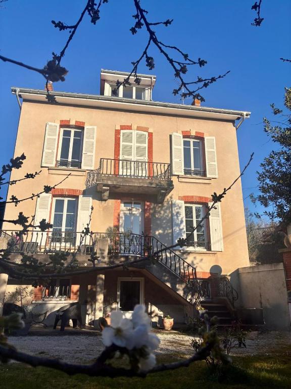 a large building with a staircase in front of it at Sous les étoiles 1 in Cusset