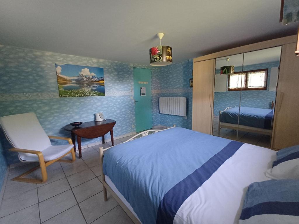 a bedroom with a bed and a chair and a desk at La Chambre du Bout du Monde in Bouillac