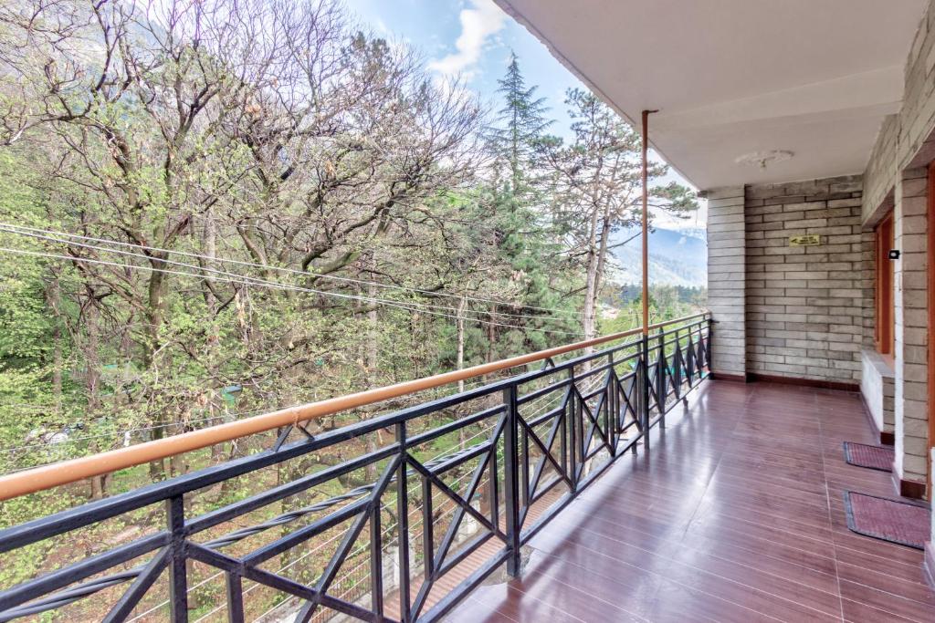 a balcony with a view of the woods at Hotel Moonlight Manali in Manāli