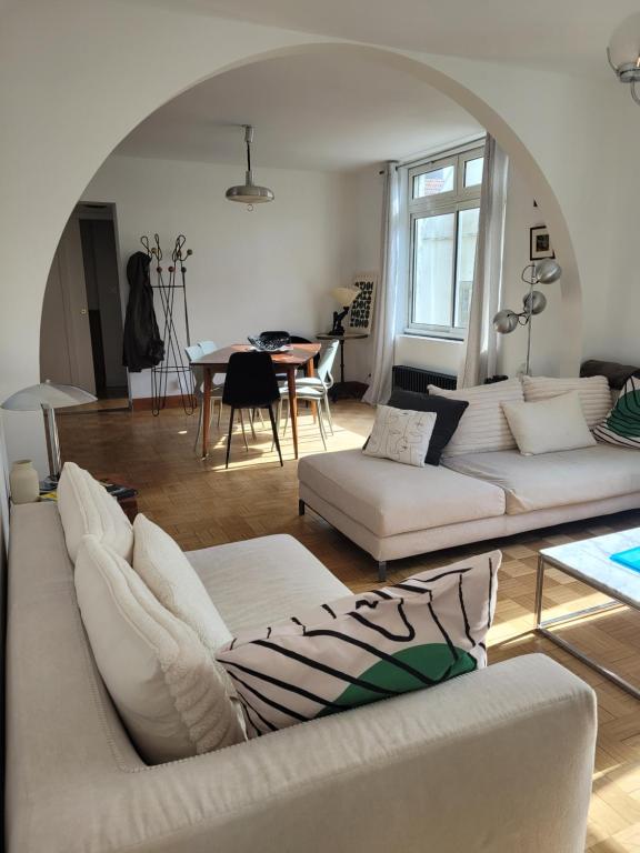 a living room with two white couches and a table at Les Aigrettes - Appartement spacieux - Terrasse et garage in Concarneau