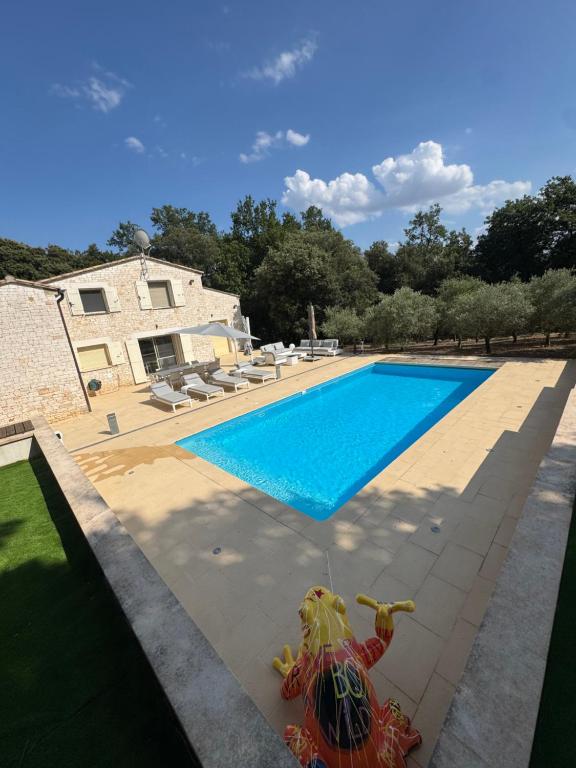 a swimming pool in front of a house at Villa Bon Cavai in Mornas