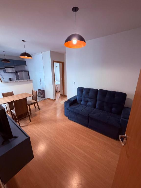 a living room with a blue couch and a table at Espaço inteiro apartamento em Londrina in Londrina