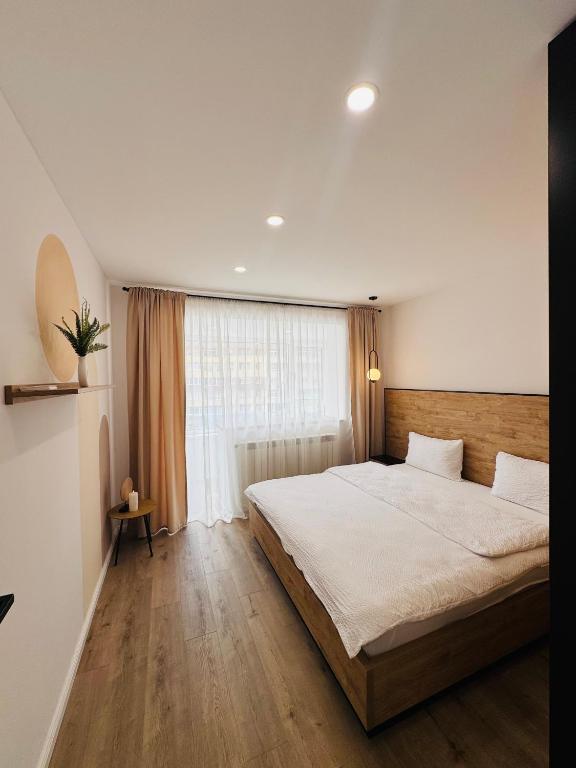 a bedroom with a large bed and a window at CentraLuxury in Piatra Neamţ