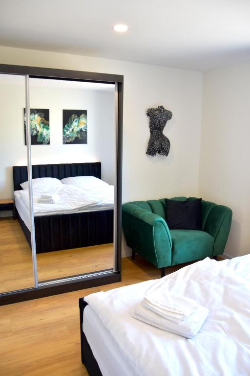 a bedroom with a mirror and a bed and a couch at Ferienwohnung Bahnblick - Stilvoll in bester Lage - als Wohnung oder Haus in Olbersdorf