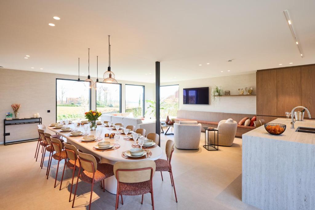 a dining room and kitchen with a long table and chairs at Vakantiewoning Belle Vue in Hooglede